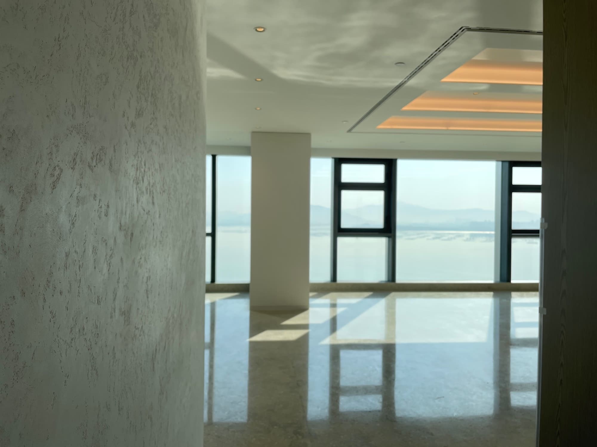 Attico panoramico con pareti spatolate e pavimento in marmo