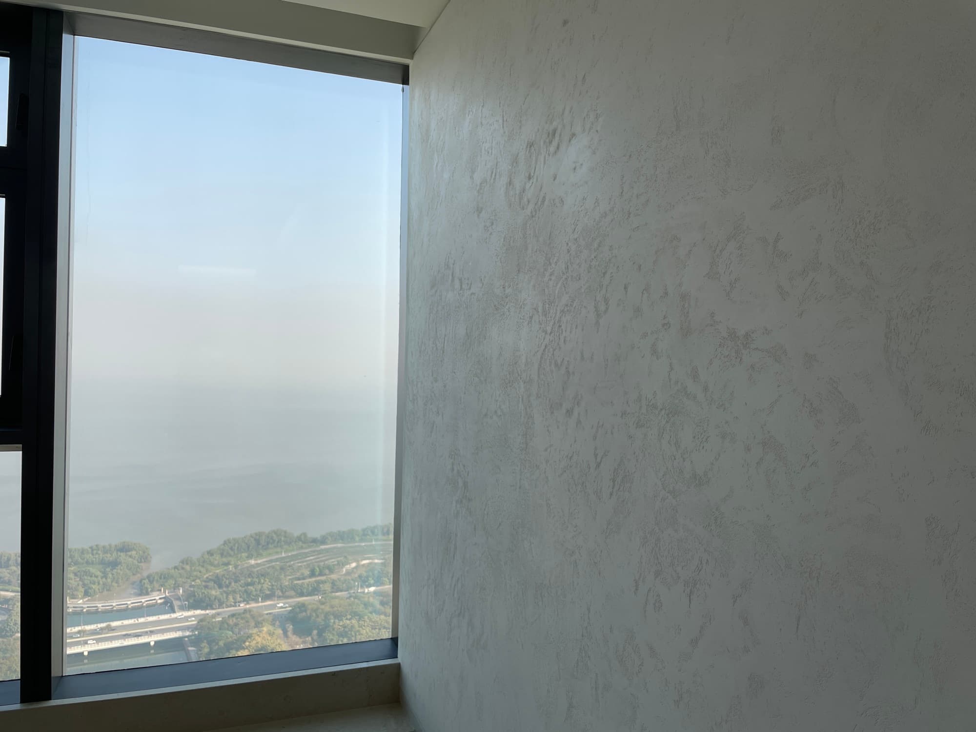 Dettaglio di parete materica accanto a vetrata panoramica