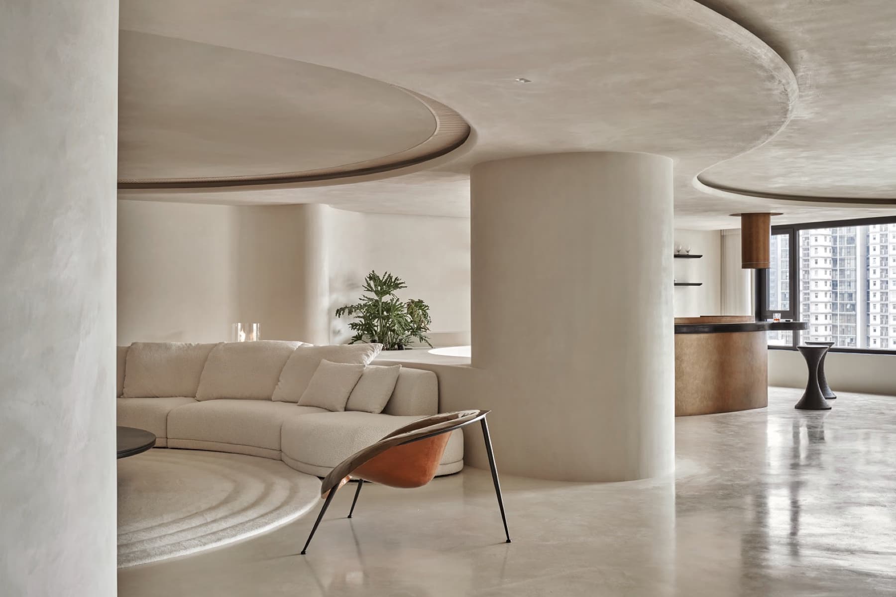 Interno con superfici continue effetto cemento e sedute curve