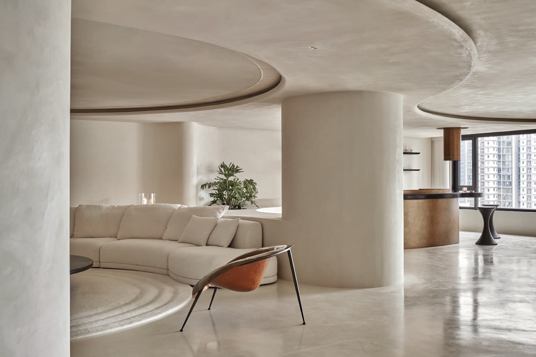 Interno con superfici continue effetto cemento e sedute curve